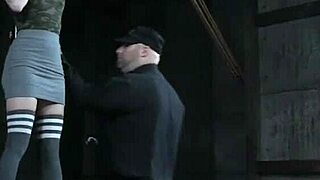 A BDSM scene with a submissive woman wearing a collar and being punished with a pussy whipping while she is tied up.