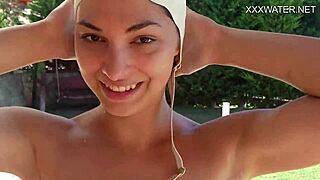Small petite brunette swims in the pool and masturbates