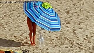 A topless European girl spies on others at the beach in Greece
