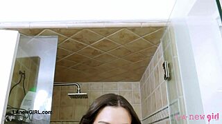 The beautiful brunette woman washes her body with soap in the bathroom