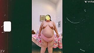 A mature cougar with saggy tits is dancing topless in front of the cam